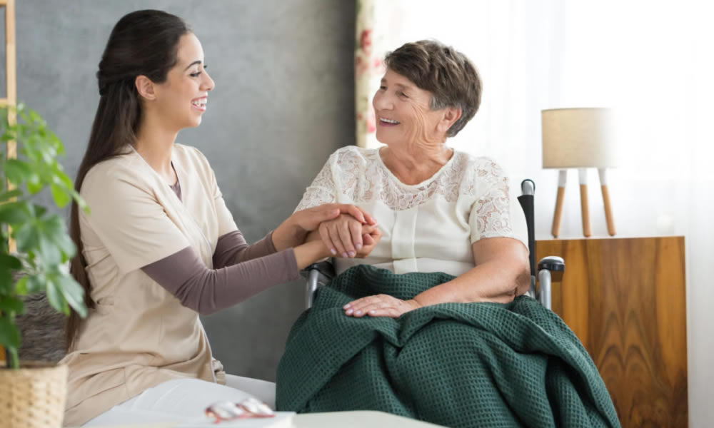 A caregiver and an older woman talking at home