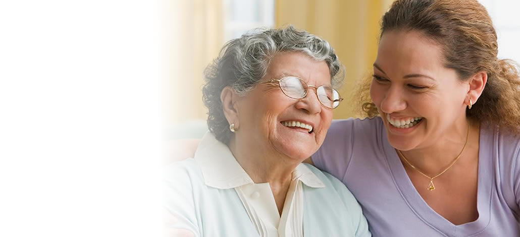 An older woman and her caregiver sharing a happy moment