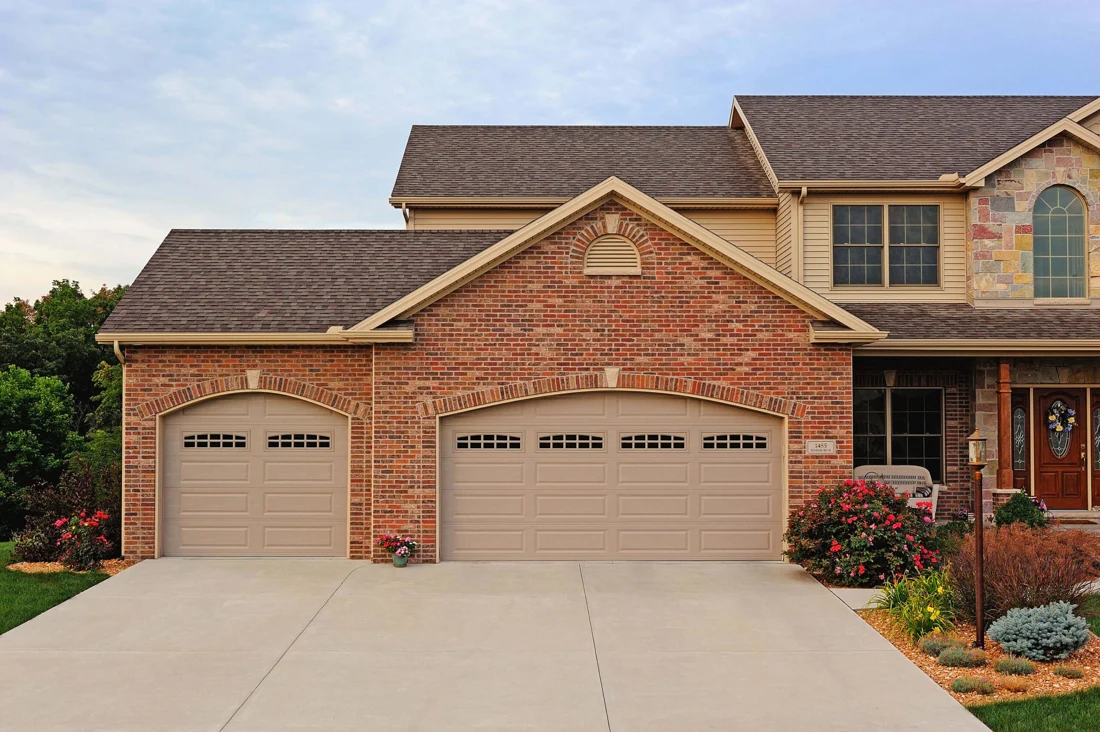 Brick home with traditional panel garage doors